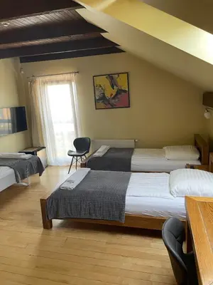 a hotel room with two beds and a window at Akmenine Kerpe in Marijampolė