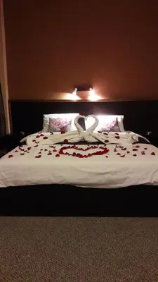 a bed with two hearts on it with roses on it at Sveciu Namai- Kazlu Ruda in Kazlų Rūda