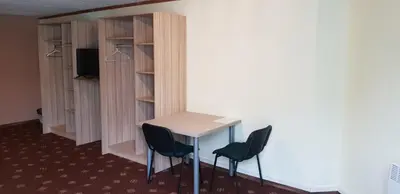 a room with a table and two chairs and a tv at Sveciu Namai- Kazlu Ruda in Kazlų Rūda