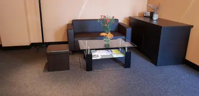 a living room with a couch and a table with a vase of flowers at Sveciu Namai- Kazlu Ruda in Kazlų Rūda