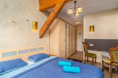 a bedroom with a blue bed and a table and chairs at Vila Sanzila in Bernatoniai