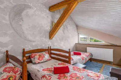 a bedroom with two beds in a attic at Vila Sanzila in Bernatoniai