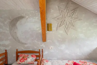 a bedroom with a wall with a painting of a star at Vila Sanzila in Bernatoniai