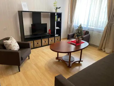 a living room with a table and a television at Cozy Center Apartment in Druskininkai in Druskininkai
