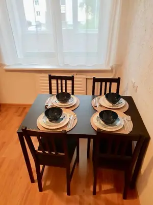 a black table with chairs and plates on it at Cozy Center Apartment in Druskininkai in Druskininkai