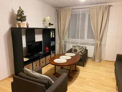a living room with a table and a television at Cozy Center Apartment in Druskininkai in Druskininkai