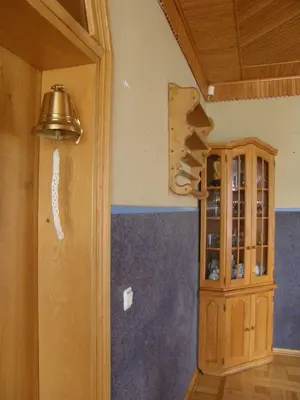 a room with a cupboard and a bell on the wall at Home for Guests Lakštingala in Šiauliai