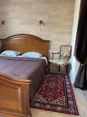 a bedroom with a bed and a chair and a rug at Apartment Vilnius Old Town in Vilnius