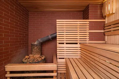 a sauna with a basket of logs and a brick wall at Anupro Villa in Trakai