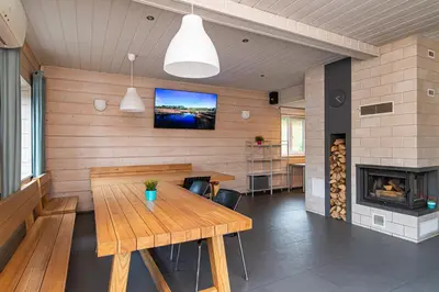 a dining room with a wooden table and a fireplace at Anupro Villa in Trakai