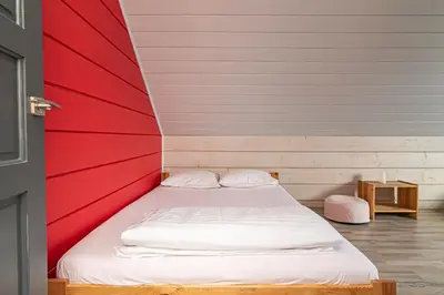 a bed in a room with a red and white wall at Anupro Villa in Trakai