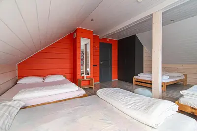 a room with two beds and a red wall at Anupro Villa in Trakai