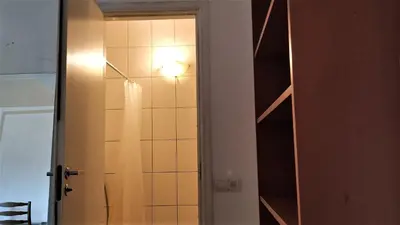 a bathroom with a shower with a light on the wall at Kaunas Homestay in Kaunas