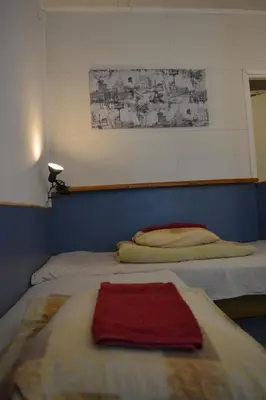 two beds in a bedroom with a red towel on them at Kaunas Homestay in Kaunas