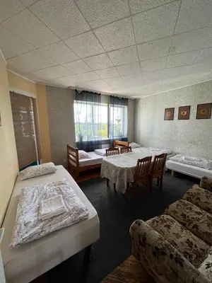 a room with two beds and a table and chairs at Kaunas Homestay in Kaunas