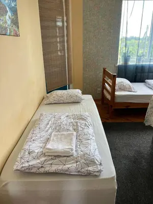 two beds sitting in a room with a window at Kaunas Homestay in Kaunas