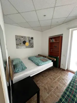 a small bedroom with a bed and a dresser at Kaunas Homestay in Kaunas