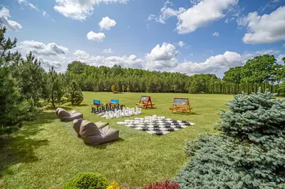 a lawn with a table and chairs in the grass at Harmony Park Countryside Villas & SPA in Prienai