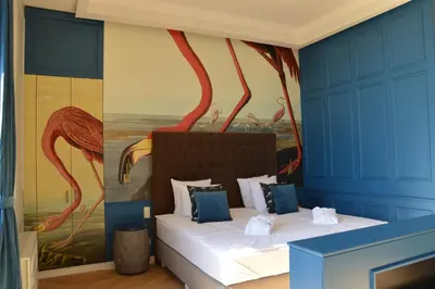 a bedroom with a painting of flamingos on the wall at Vytautas Mineral SPA in Birštonas