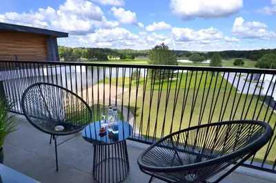 a patio with two chairs and a table on a balcony at Vytautas Mineral SPA in Birštonas