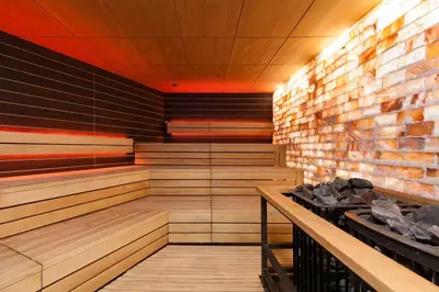 a sauna with wooden floors and a brick wall at Vytautas Mineral SPA in Birštonas