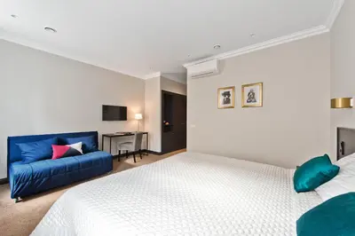 a bedroom with a bed and a blue couch at 15th Avenue in Vilnius