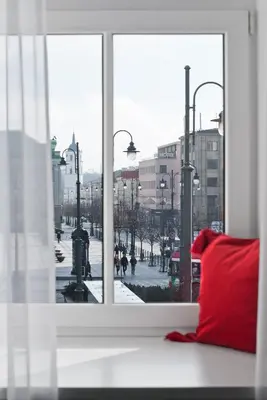 a view of a city from a window with a red pillow at 15th Avenue in Vilnius
