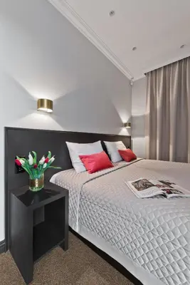 a bedroom with a bed and a table with flowers on it at 15th Avenue in Vilnius