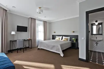 a bedroom with a bed and a desk and a sink at 15th Avenue in Vilnius