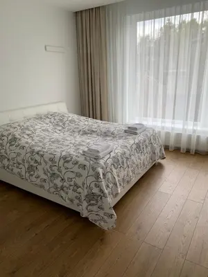 a bedroom with a bed and a window with curtains at Apartamentai Fortuna in Kaunas