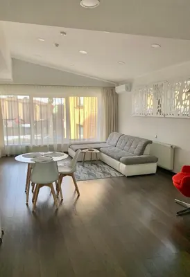 a living room with a couch and a table and chairs at Apartamentai Fortuna in Kaunas