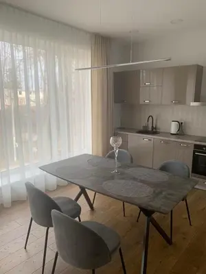 a table and chairs in a kitchen with a table at Apartamentai Fortuna in Kaunas