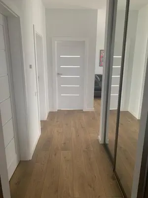 a room with a mirror and a hallway with wood floors at Apartamentai Fortuna in Kaunas