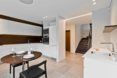 a kitchen and dining room with a table and a sink at Ami Residence Forest in Didžiasalis