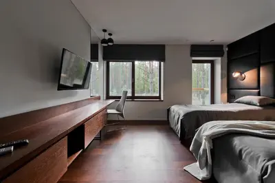 a bedroom with two beds and a desk with a television at Ami Residence Forest in Didžiasalis