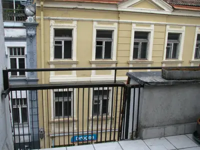 a view of a yellow building from a balcony at Pilies Street Sanctuary Secure Old Town Apartmen in Vilnius