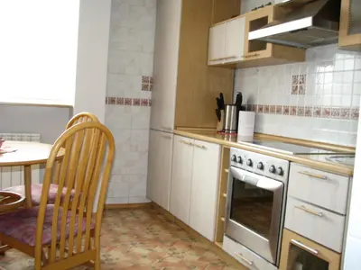 a kitchen with a stove and a table in it at Pilies Street Sanctuary Secure Old Town Apartmen in Vilnius