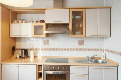 a kitchen with white cabinets and a sink at Pilies Street Sanctuary Secure Old Town Apartmen in Vilnius