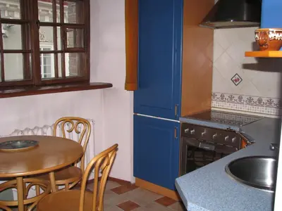 a kitchen with a table and a blue refrigerator at Pilies Street Sanctuary Secure Old Town Apartmen in Vilnius
