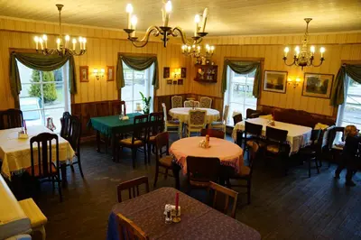 a dining room with tables and chairs and a room with yellow walls at Labanoras in Labanoras