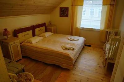 a bedroom with a large bed with a wooden floor at Labanoras in Labanoras