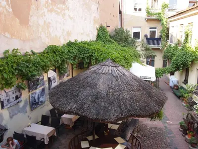 a patio with an umbrella and tables and chairs at Gabi B&B in Vilnius