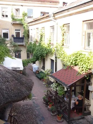 a building with a table in a courtyard with plants at Gabi B&B in Vilnius