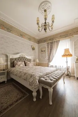 a bedroom with a large bed and a chandelier at Gabi B&B in Vilnius