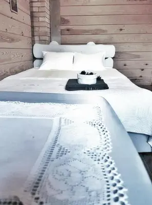 a white bed with a bowl on top of it at Trainiškio pirkia in Ginučiai