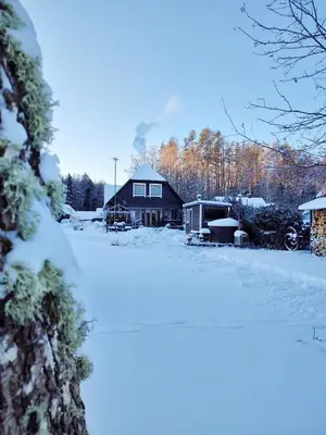 a house with snow on the ground in front of it at Trainiškio pirkia in Ginučiai