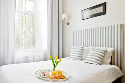 a white bed with a tray of food on it at Cozy studio in Old Town by URBAN RENT in Vilnius
