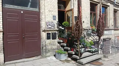 a red door of a building with flowers on the steps at Cozy studio in Old Town by URBAN RENT in Vilnius