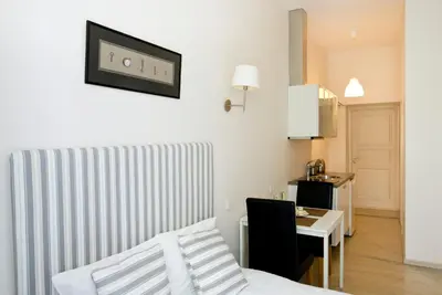 a living room with a bed and a table and a room at Cozy studio in Old Town by URBAN RENT in Vilnius