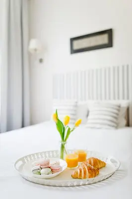a tray with a plate of food on a bed at Cozy studio in Old Town by URBAN RENT in Vilnius